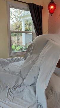 fluffing a top sheet like a parachute