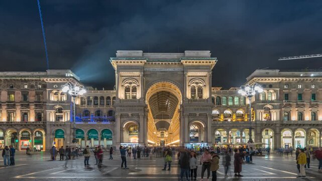 Night timelapse of the illuminated entrance to Galleria Vittorio Emanuele II in Milan featuring magnificent historic architecture and one of Italy's most iconic landmarks.
