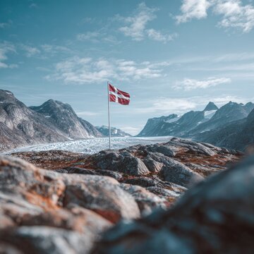 Territorial triumph: the flag above an icy wilderness. Cinematic glow. Greenland's emblem amidst rocky glaciers and partially sunny skies in the arctic. Color blocking. Futuristic design.