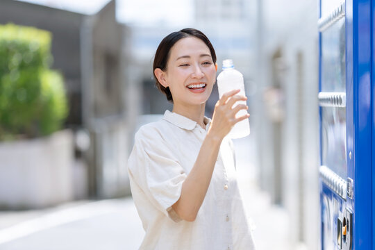 水を飲む女性　自動販売機