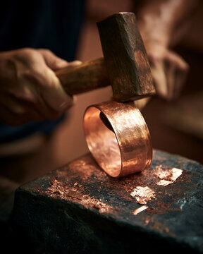 Copper bangle and ring metalworking in workshop with artisan tools for handcrafted jewelrymaking process
