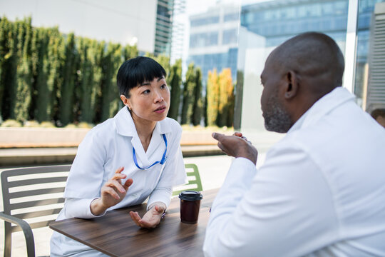 Doctors discussing patient care outdoors at hospital