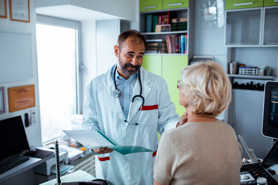 Male doctor discussing results with senior woman in clinic