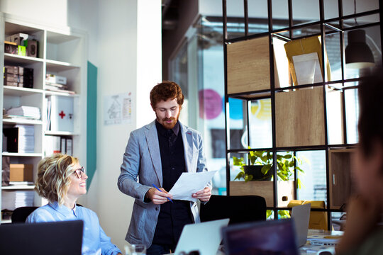 Business team reviewing documents in modern open office