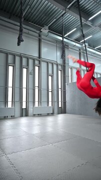 A graceful gymnast trains on an aerial hoop.