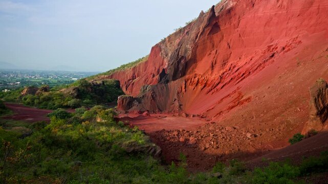 Open pit mine with red soil revealing strata