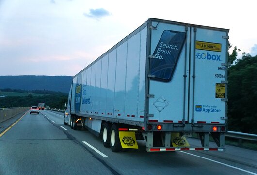 Pennsylvania, U.S.A - Jul 18, 2026 - A white J.B Hunt trailer promoting 360Box digital freight platform traveling on a highway surrounded by trees and hills.