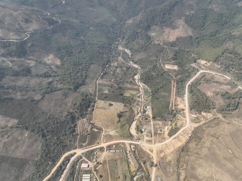 Stunning top-down aerial drone photograph of lush green agricultural fields, crop patterns, and rural countryside. Excellent for themes related to farming, sustainable agriculture, environmental studi