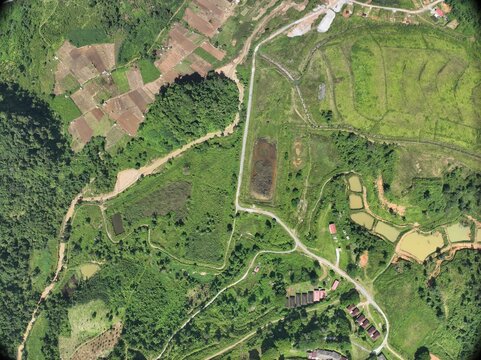 Stunning top-down aerial drone photograph of lush green agricultural fields, crop patterns, and rural countryside. Excellent for themes related to farming, sustainable agriculture, environmental studi