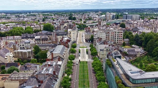 Drone flying above Boulevard du Mar&eacute;chal Foch, revealing the tram corridor, surrounding buildings and downtown Angers, France.