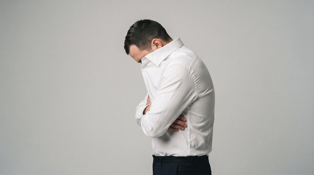 Side view of a man in a white shirt with his head bowed and arms crossed, expressing sadness, shame, or deep contemplation
