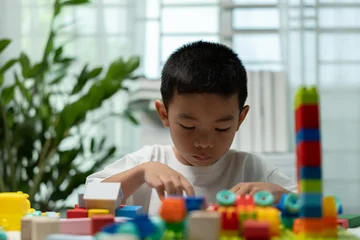 Fotobehang Lego Young child learning through colorful building blocks and creative play at home, developing fine motor skills, problem solving, concentration, early education, cognitive growth, childhood development.  © Father_Studio