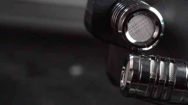 Macro close up of professional microphone grille and metal mesh showcasing precision engineering and audio recording equipment with selective focus indoors