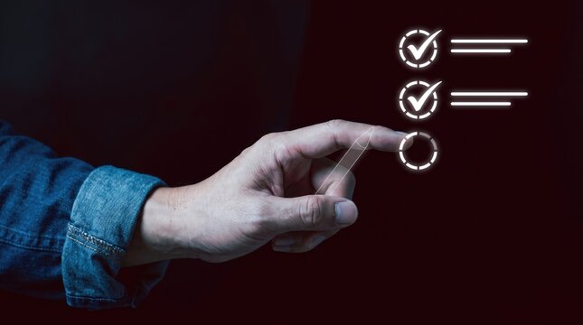 Hand selecting option from glowing checklist during dark illuminated workflow