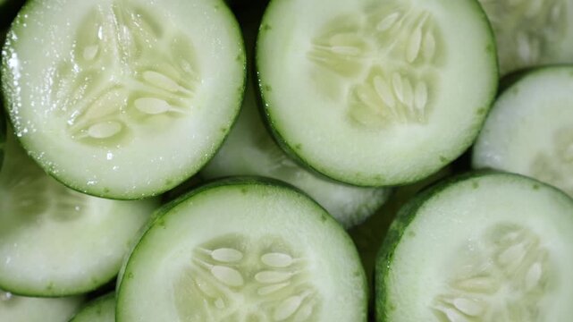 Close-up of fresh sliced cucumber showcasing its crisp texture, vibrant green skin, and juicy interior. Ideal for themes of healthy eating, organic vegetables, fresh produce, salad ingredients, nutrit