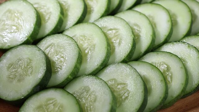 Close-up of fresh sliced cucumber showcasing its crisp texture, vibrant green skin, and juicy interior. Ideal for themes of healthy eating, organic vegetables, fresh produce, salad ingredients, nutrit