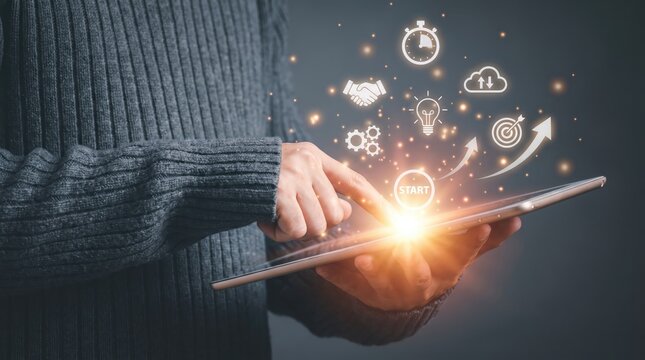 Person's fingers touching tablet screen with glowing digital icons of business growth and strategy during a bright light flare