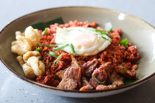 Favorful red pork fried rice topped with a sunny-side-up fried egg, and crispy pork cracklings.