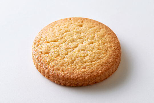 Golden round cookie with a cracked surface on a white background