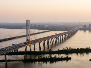 Fototapeta premium Cable stayed bridge over St Lawrence River at golden sunrise near Montreal and Brossard, Canada. g.