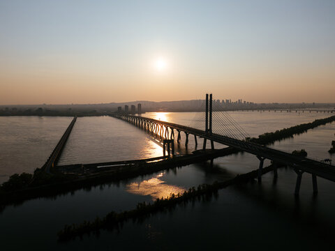 Cable stayed bridge over St Lawrence River at golden sunrise near Montreal and Brossard, Canada. g.