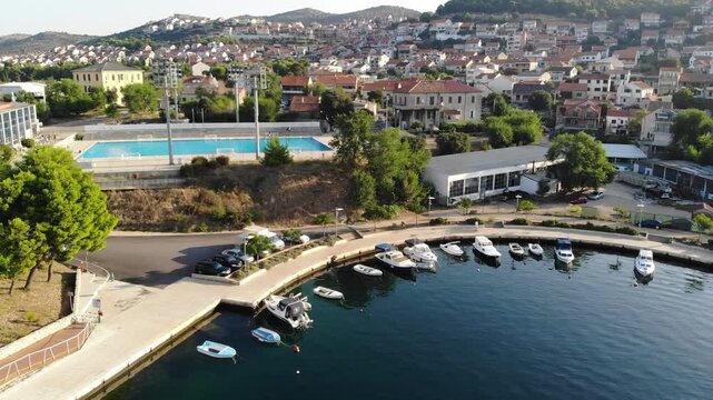 Aerial view of the &Scaron;ibenik waterfront featuring the marina, crystal clear Adriatic Sea and the historic city on the Croatian coast.