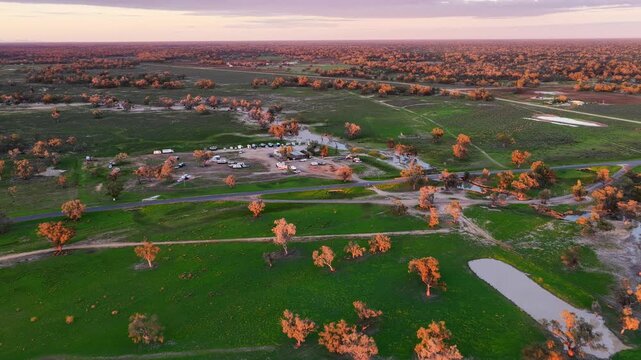 Aerial video flying over the Pilliga Artesian Bore Baths and adjacent campground in Pilliga, NSW, Australia. The naturally heated artesian baths are surrounded by native bushland