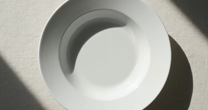Simple white plate overhead view soft light shadows
