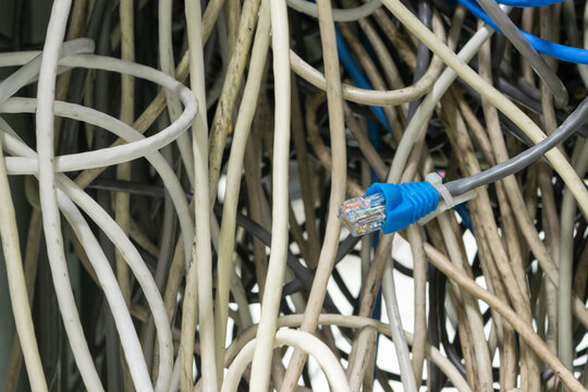 Tangled network cables ethernet connector inside communication cabinet highlighting data infrastructure cable management maintenance information technology systems