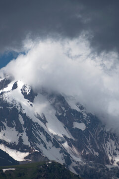High Mount Kazbek slopes under heavy storm clouds and fog in Georgia with copy space