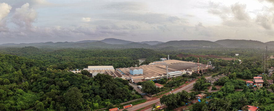 Large tyre manufacturing complex spread across a valley below forested hills