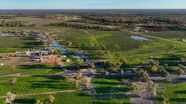 Aerial video flying over the Pilliga Artesian Bore Baths and adjacent campground in Pilliga, NSW, Australia. The naturally heated artesian baths are surrounded by native bushland
