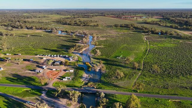 Aerial video flying over the Pilliga Artesian Bore Baths and adjacent campground in Pilliga, NSW, Australia. The naturally heated artesian baths are surrounded by native bushland