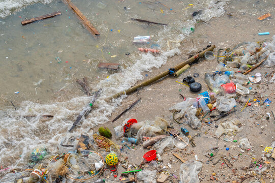 Polluted beach with plastic waste and garbage washed up on the shore, environmental pollution and ocean waste concept, ecological problem on tropical coast	
