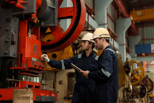 A team of engineers and staff are inspecting the production line system at a metal sheet and roofing factory. (PHOTO)	