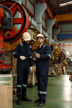 A team of engineers and staff are inspecting the production line system at a metal sheet and roofing factory. (PHOTO)	