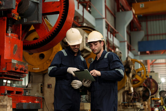 A team of engineers and staff are inspecting the production line system at a metal sheet and roofing factory. (PHOTO)	