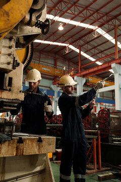 A team of engineers and staff are inspecting the production line system at a metal sheet and roofing factory. (PHOTO)	