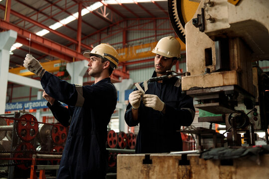 A team of engineers and staff are inspecting the production line system at a metal sheet and roofing factory. (PHOTO)	