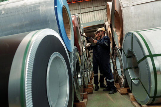A team of engineers and staff are inspecting the production line system at a metal sheet and roofing factory. (PHOTO)	