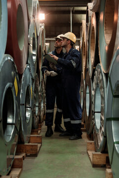 A team of engineers and staff are inspecting the production line system at a metal sheet and roofing factory. (PHOTO)	