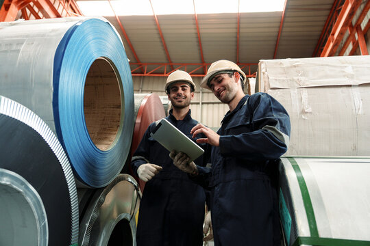 A team of engineers and staff are inspecting the production line system at a metal sheet and roofing factory. (PHOTO)	