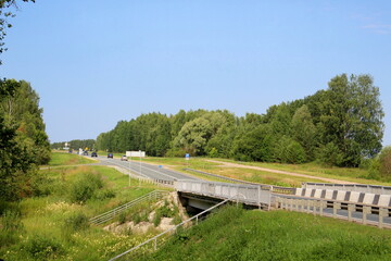 Fototapeta premium Automobile bridge across the river in summer.