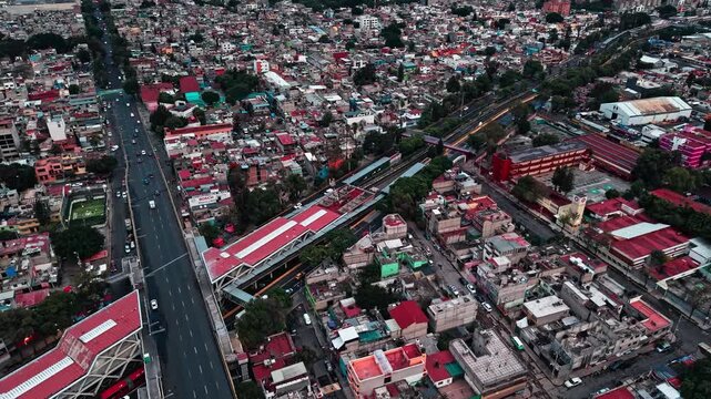 4K aerial drone footage of an urban transportation intersection with a highway bridge, metro line, vehicles and residential areas viewed from above.