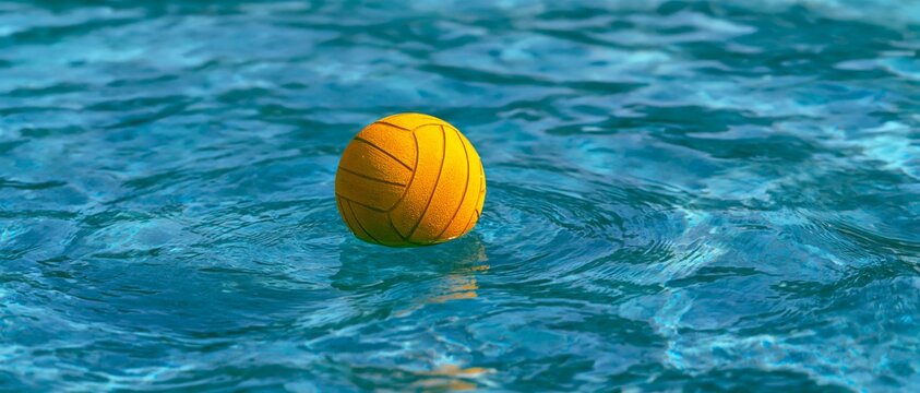 Yellow ball floats gently in clear blue water. 64k 8k widescreen, HDR