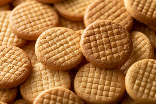 Golden round butter cookies with crisscross patterns filling the frame