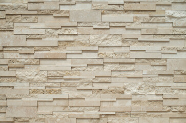 Fototapeta premium Modern relief decorative stacked stone wall cladding texture in beige tone