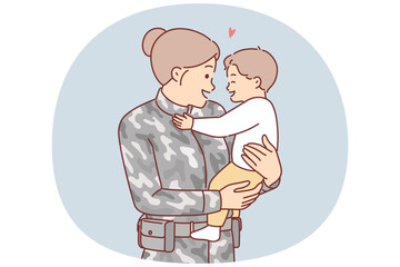 Woman soldier holds little son, who is rejoicing when mother returns home after military service