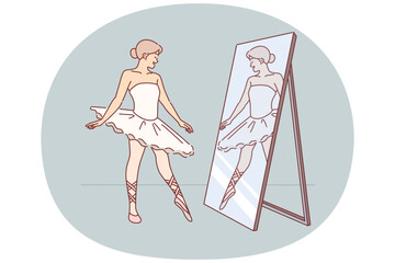 Woman ballerina looks in mirror with smile, practicing to pull toe before performing on stage © Valery