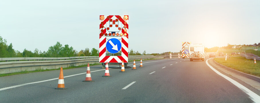 Striped barricades and construction truck direct traffic